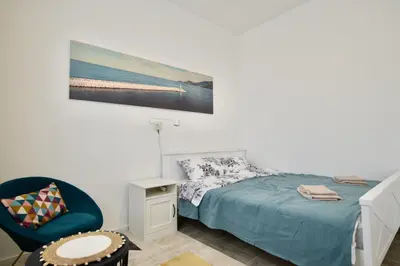 a bedroom with a bed and a blue chair at TriA Studio in Bar