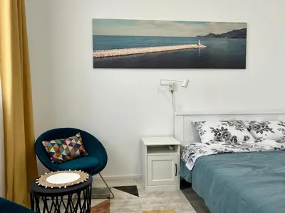 a bedroom with a bed and a chair and a picture at TriA Studio in Bar