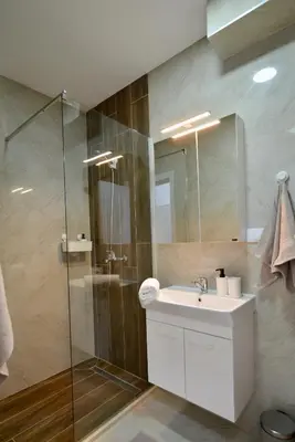 a bathroom with a sink and a glass shower at TriA Studio in Bar