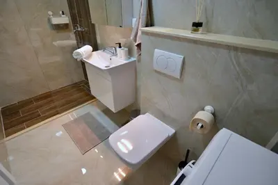 a bathroom with a white toilet and a sink at TriA Studio in Bar