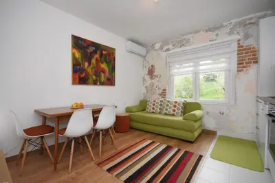 a living room with a green couch and a table at Brick house in Cetinje