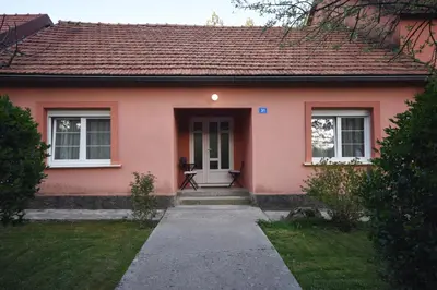 a small pink house with a white door at Brick house in Cetinje