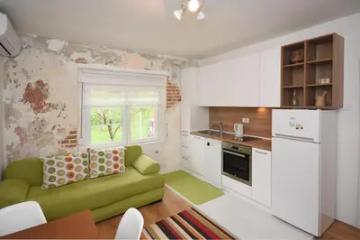 a living room with a green couch in a kitchen at Brick house in Cetinje