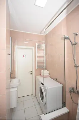 a bathroom with a washing machine and a shower at Brick house in Cetinje