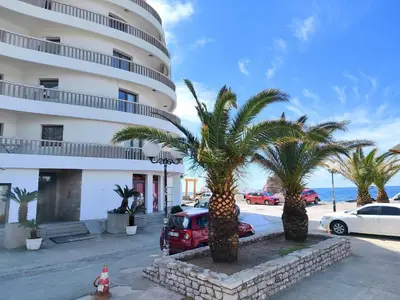 a hotel with palm trees in front of a building at Net in Rafailovici