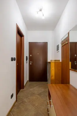 a hallway with a wooden door and a kitchen at Net in Rafailovici