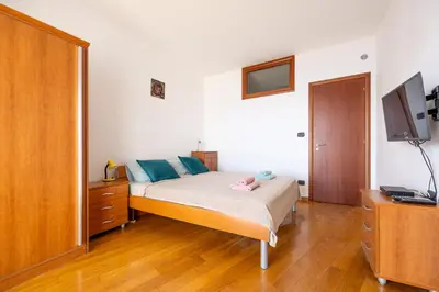 a bedroom with a bed with blue pillows and a television at Net in Rafailovici