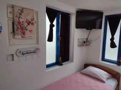 a bedroom with a bed and a flat screen tv at Bay Mola Home in Kotor