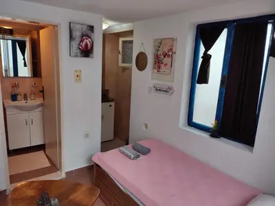 a small room with a pink bench and a sink at Bay Mola Home in Kotor