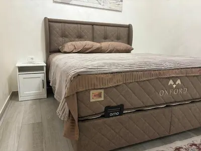 a bed with a brown comforter in a bedroom at Petar Apartment in Podgorica