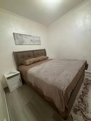 a bedroom with a large bed with a night stand at Petar Apartment in Podgorica