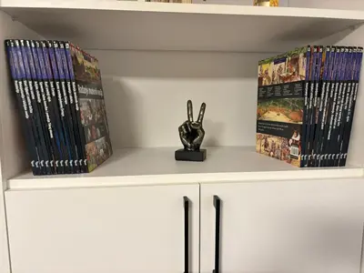 a shelf with dvds and a vase on it at Petar Apartment in Podgorica