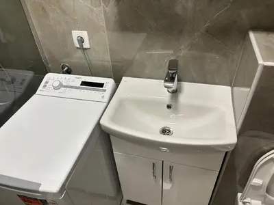 a bathroom with a white sink and a toilet at Petar Apartment in Podgorica