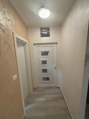 a hallway with a white door and a light at Petar Apartment in Podgorica