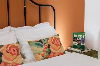 a bed with two pillows and a book on a table at Classy & Central Apartment David (parking included) in Virpazar