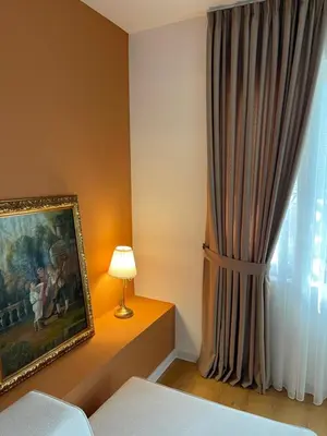a bedroom with a painting and a lamp next to a window at Classy & Central Apartment David (parking included) in Virpazar