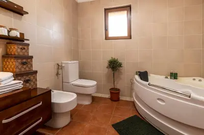 a bathroom with a toilet and a tub and a sink at Classy & Central Apartment David (parking included) in Virpazar