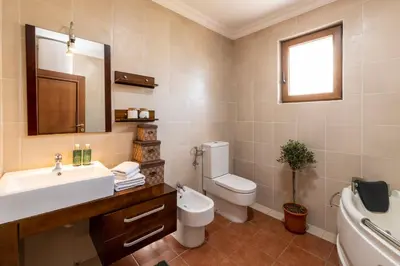 a bathroom with a sink and a toilet and a mirror at Classy & Central Apartment David (parking included) in Virpazar