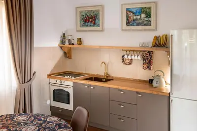 a small kitchen with a sink and a refrigerator at Classy & Central Apartment David (parking included) in Virpazar