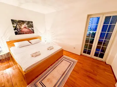 a bedroom with a bed and a large window at Mia Apartment in Budva