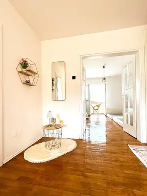 an empty living room with a table on a wooden floor at Mia Apartment in Budva