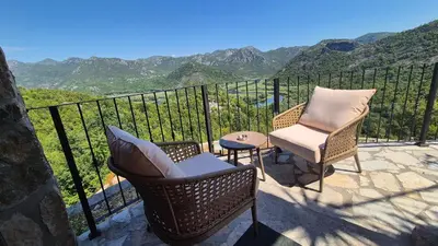 a balcony with two chairs and a table with a view at Rooms Dujeva Drago-Resort in Rijeka Crnojevića