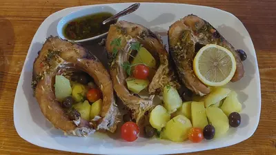 a plate of food with fruit on a table at Rooms Dujeva Drago-Resort in Rijeka Crnojevića