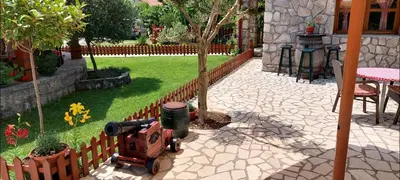 a toy train next to a tree in a yard at Rooms Dujeva Drago-Resort in Rijeka Crnojevića