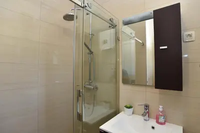 a bathroom with a shower and a sink and a mirror at Apartments Jelušić in Budva