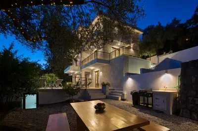 a large white house with a table in front of it at Villa Fotinia in Budva