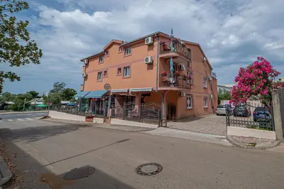 a pink building on the corner of a street at Apartment Marcic in Bar