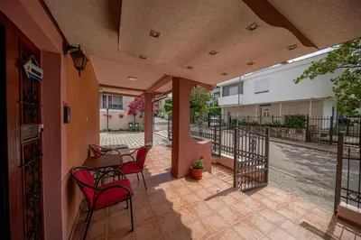 a patio with chairs and a table and a street at Apartment Marcic in Bar