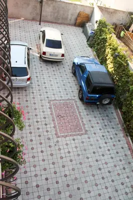 two cars parked on a tiled parking lot at Apartment Marcic in Bar