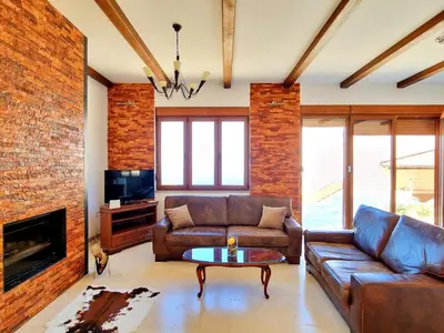 a living room with leather furniture and a brick wall at Luxury Villa Pontus in Kotor