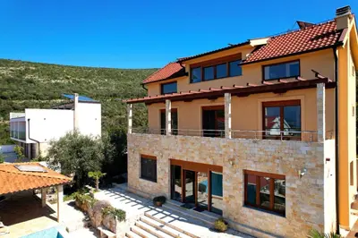 a house with a hill in the background at Luxury Villa Pontus in Kotor