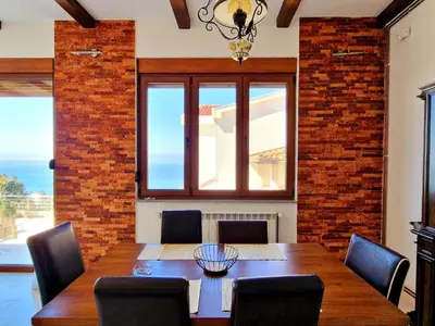 a dining room with a table and a brick wall at Luxury Villa Pontus in Kotor