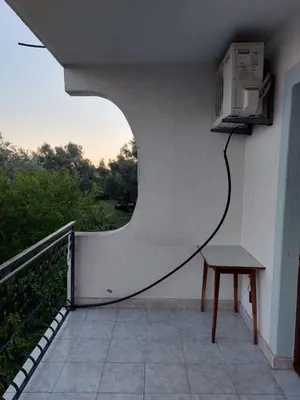 a balcony with a table and a tv on the wall at PEKOVIĆ in Bar