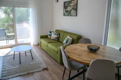 a living room with a green couch and a table at Olive Grove in Bar