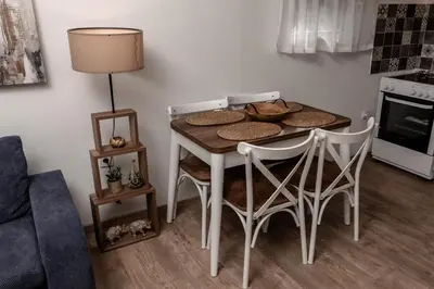 a dining room table with four chairs and a lamp at Olive Grove in Bar