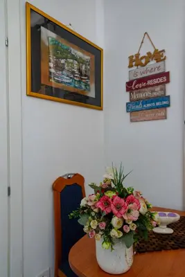 a table with a vase of flowers on a table at Vila apartment Astorija 2 in Podgorica
