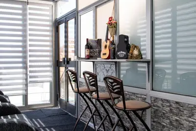 a room with four chairs and a table with a guitar at Vila apartment Astorija 2 in Podgorica