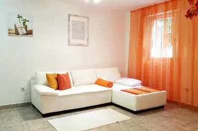 a living room with a white couch and a window at Apartment with a garden Petrovac in Petrovac na Moru