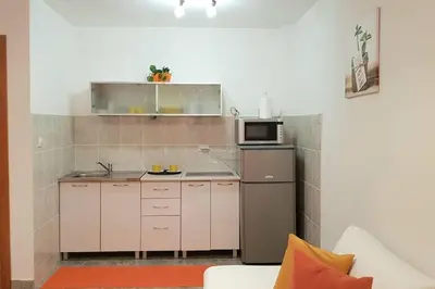 a small kitchen with a microwave and a stove at Apartment with a garden Petrovac in Petrovac na Moru