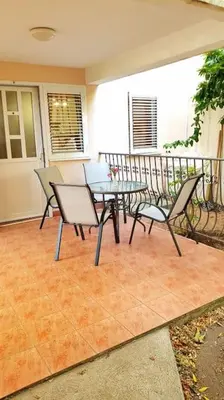 a patio with a table and chairs on a balcony at Apartment with a garden Petrovac in Petrovac na Moru