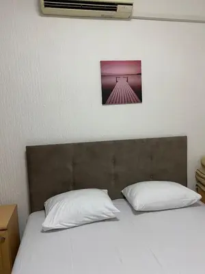a bedroom with a bed with two pillows and avertisement at MICIC CENTRE in Budva