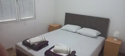 a bedroom with a white bed with three pillows at MICIC CENTRE in Budva