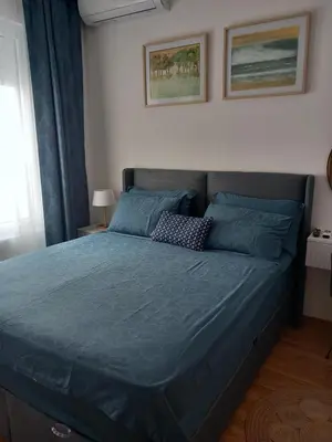 a bedroom with a bed with a blue comforter at LUX Apartment Secret Residence in Becici