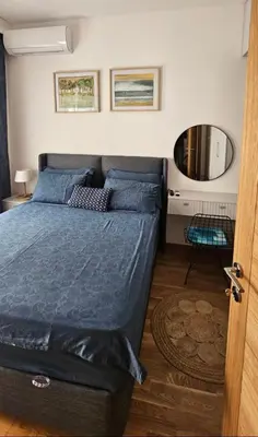 a bedroom with a bed with blue sheets and a mirror at LUX Apartment Secret Residence in Becici