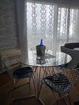 a glass table with chairs and a blue vase on it at Tecasi Lux Apartments in Budva