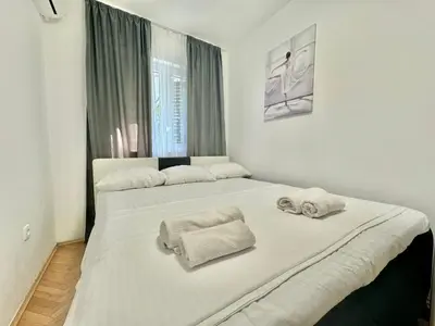 a bedroom with a large white bed with towels on it at Family One bedroom apartment Marijana in Budva